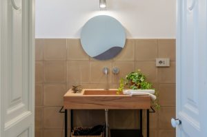 B&B a Zollino Dimora la Fuga_3, Bagno con Lavabo in struttura di legno e specchio tondo.